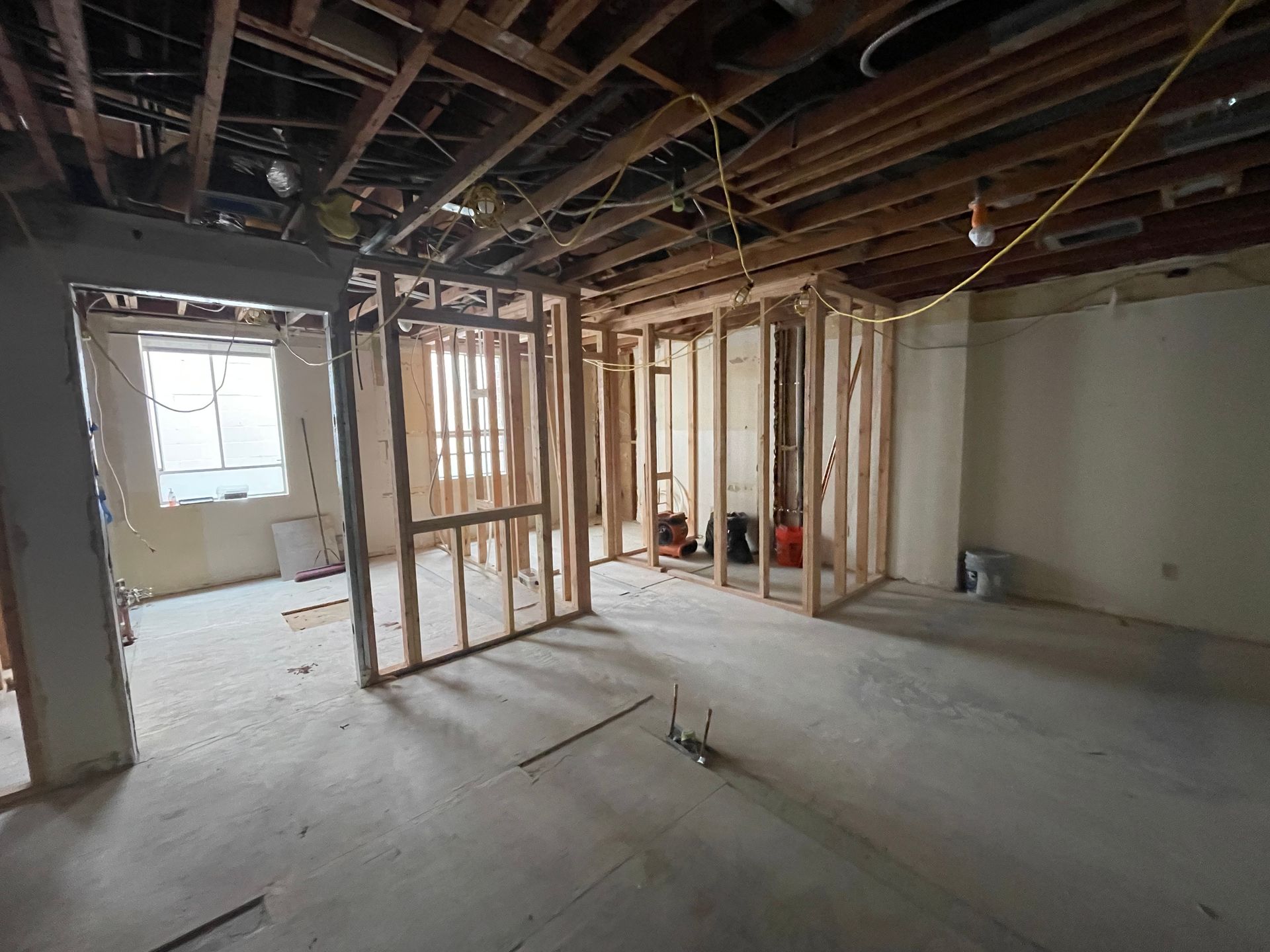 Unfinished basement with exposed wood framing, open ceiling beams, and concrete floor.