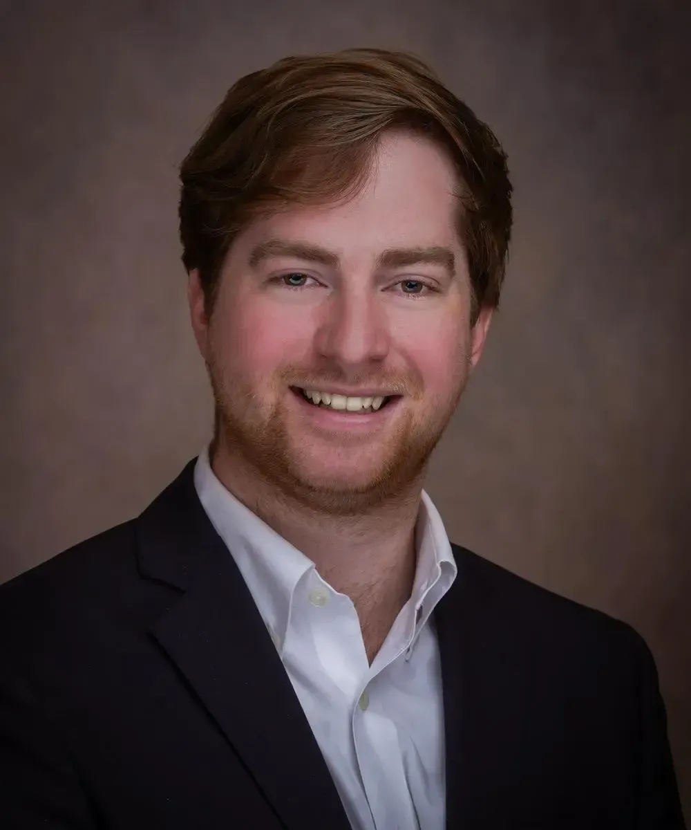 Fiduciary Derek Lewis in a tie is smiling.