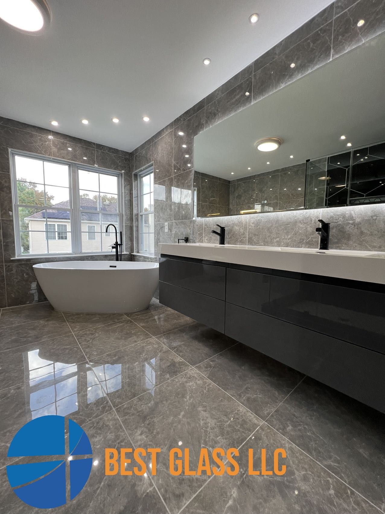 A bathroom with two sinks , a bathtub and a large mirror.