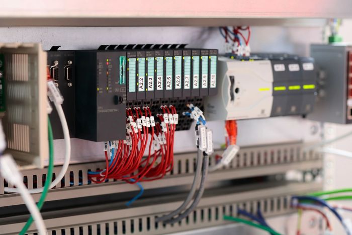 Quadro elettrico con moduli PLC e cablaggio.