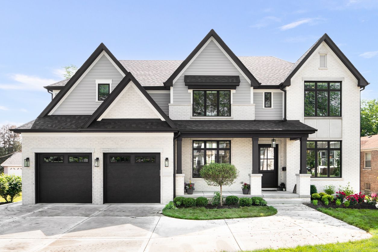 Modern two-story white house with black trim, double garage, and manicured front yard