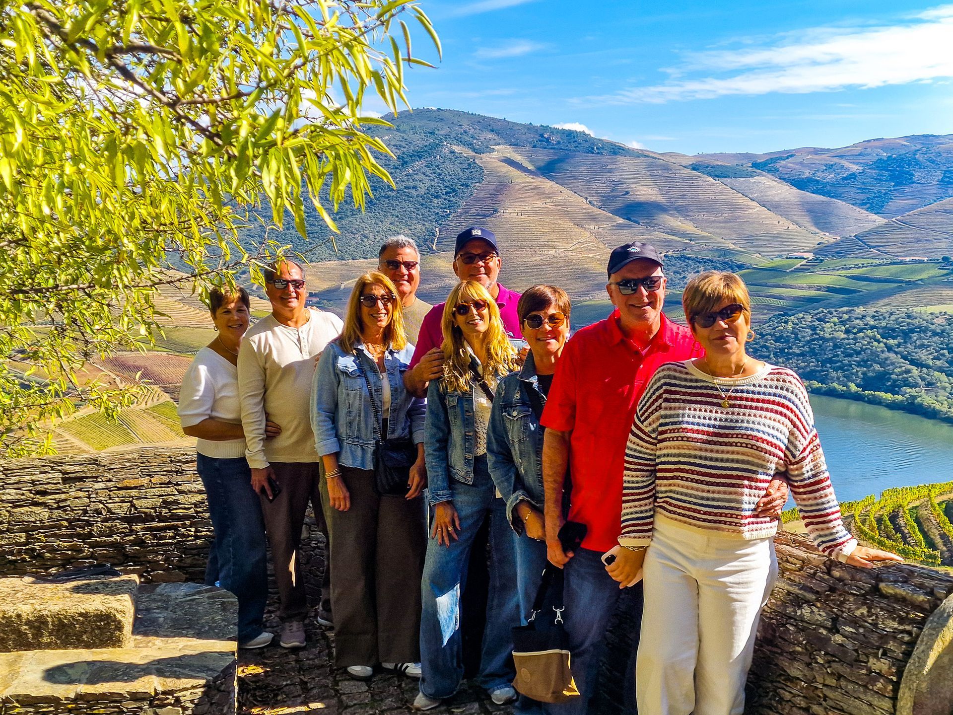 Happy friends stopping in Douro Valley for a visit and a wine tasting during a transfer from Lisbon to Porto with Duca