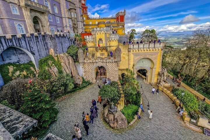 Pena Palace on its hilltop in Sintra, with visitors in the courtyard below