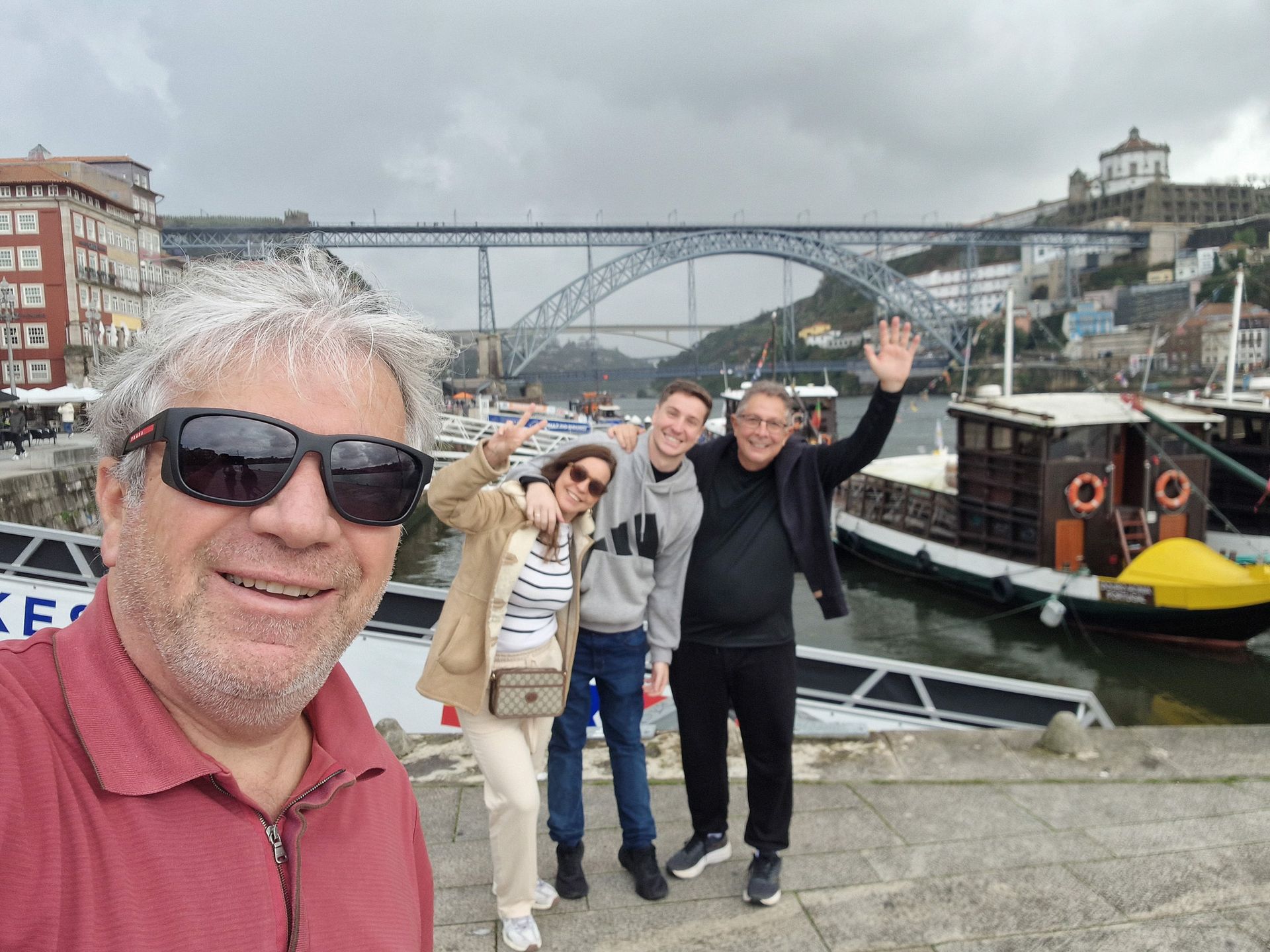Guia Rui da Duca sorrindo com clientes felizes na Ribeira do Porto, com a Ponte Luís I e a Serra do Pilar como pano de fundo.