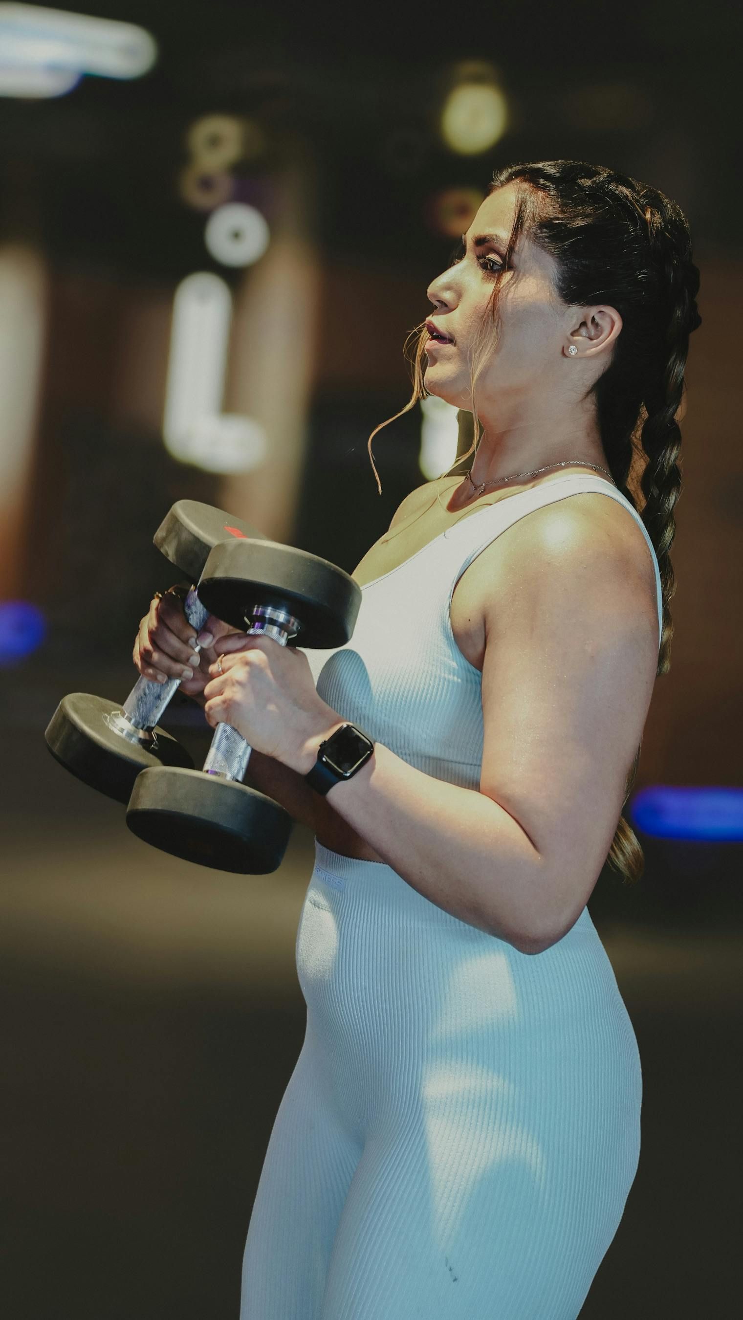 Mensen die onder begeleiding van een trainer in een sportschool met gewichten trainen.