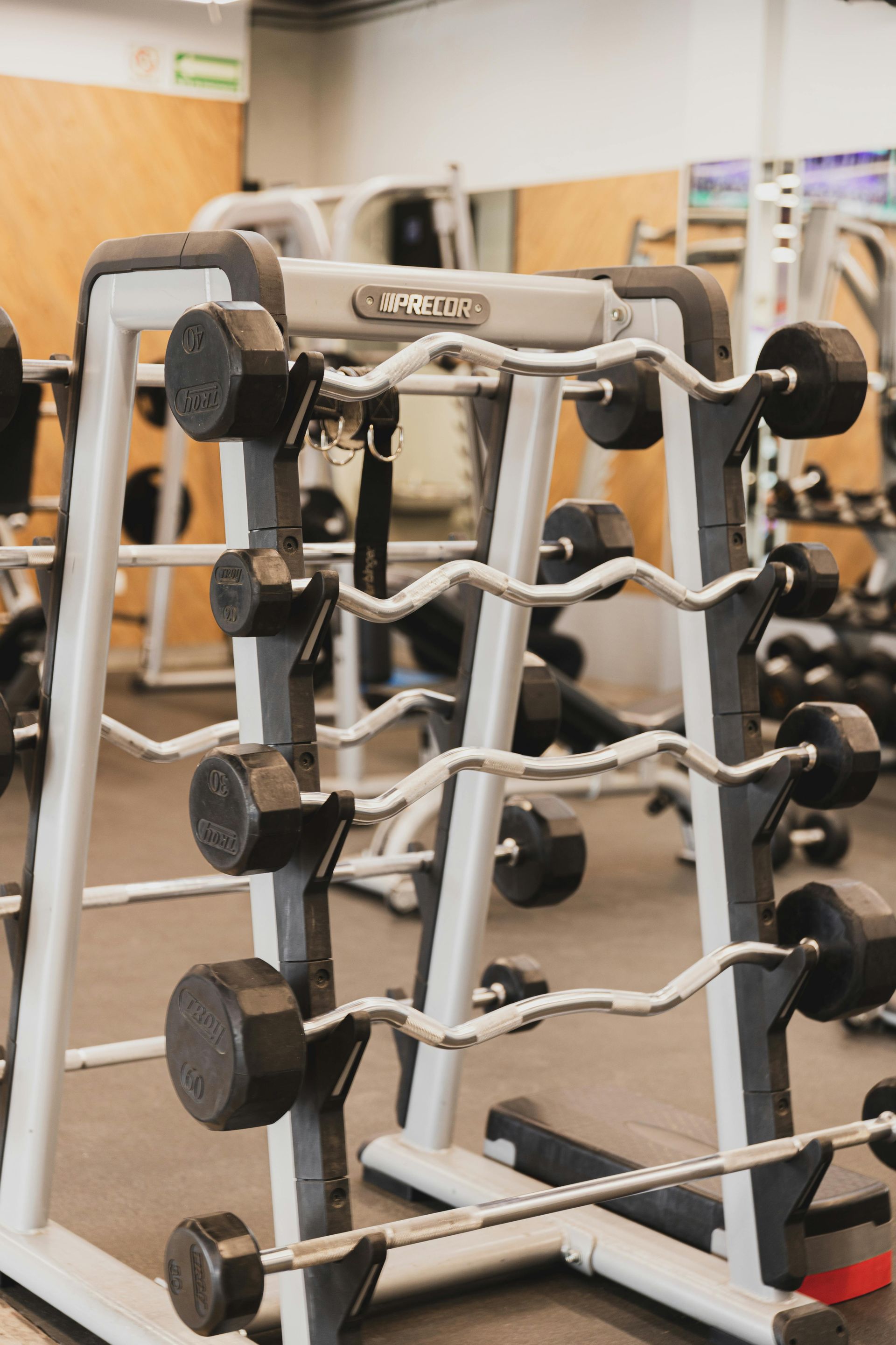 Interieur van een moderne sportschool met fitnessapparatuur en paarse neonverlichting.