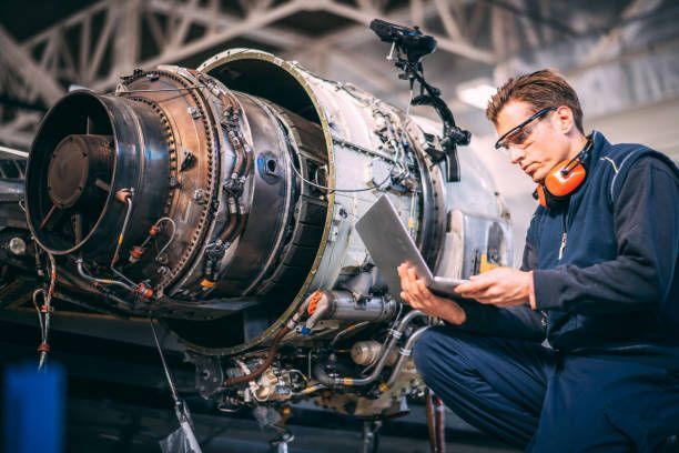 An aircraft mechanic who just received a same day AOG part, working on a jet engine 