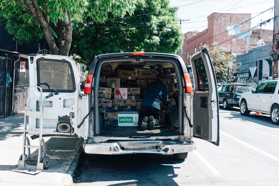 A white van is parked on the side of the road with its doors open