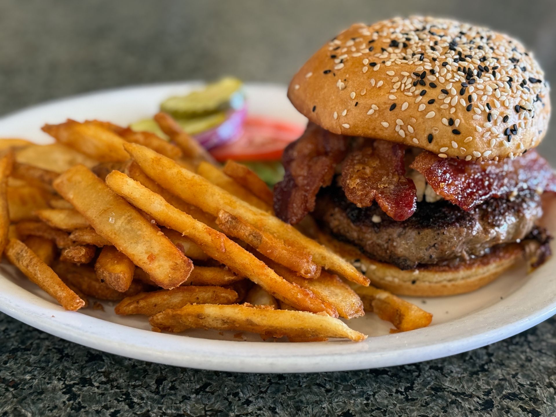 A hamburger and french fries on a white plate.