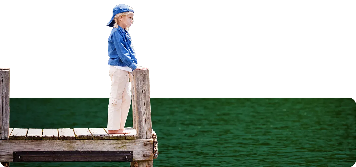 Child appearing homesick or feeling alone on dock.
