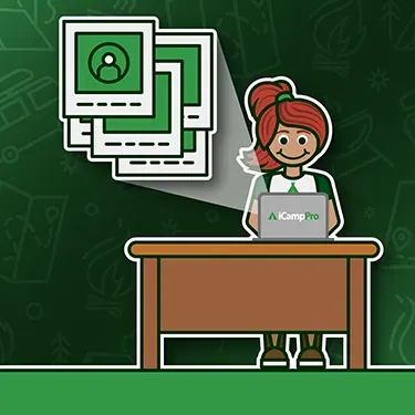 A woman is sitting at a desk using a laptop computer.