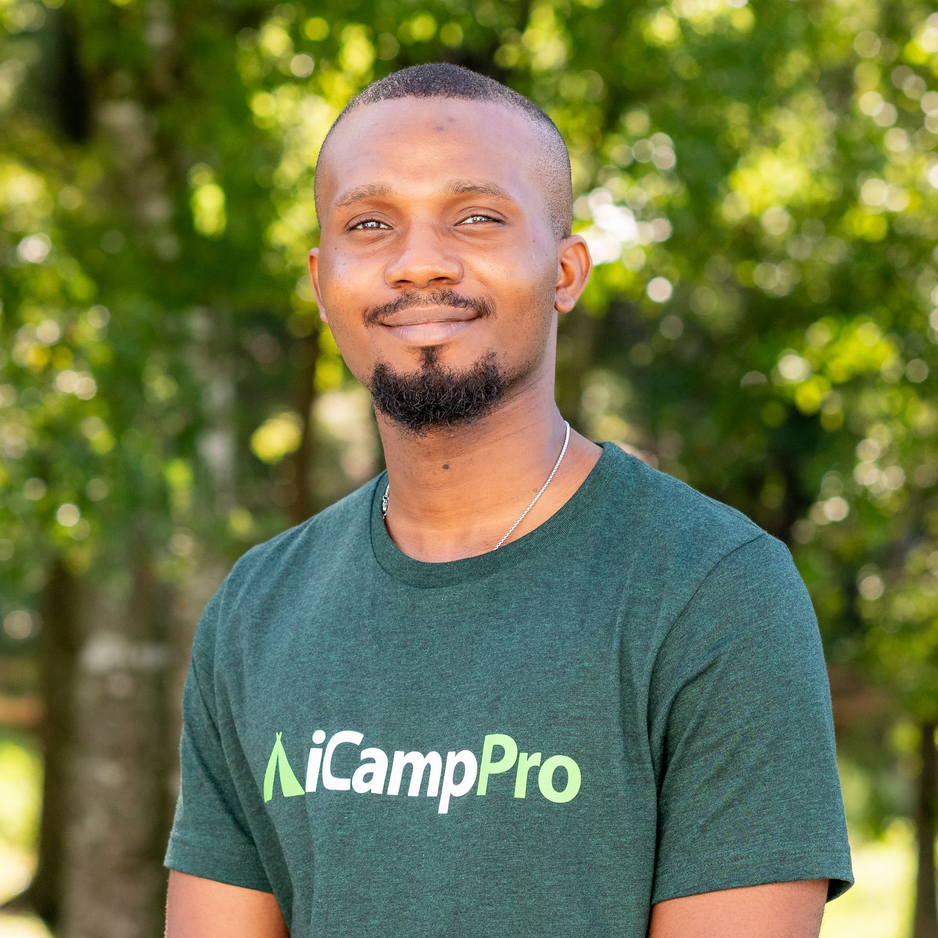 A man in a green AiCampPro t-shirt