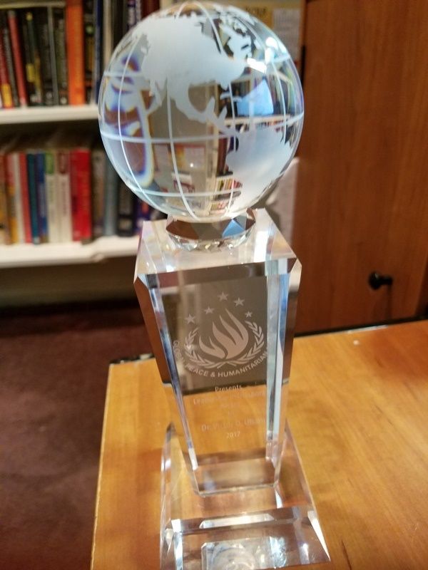 A glass trophy with a globe on top of it