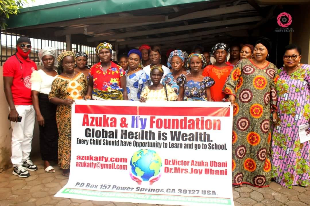 A group of people standing in front of a sign that says azuka & lily foundation global health is wealth