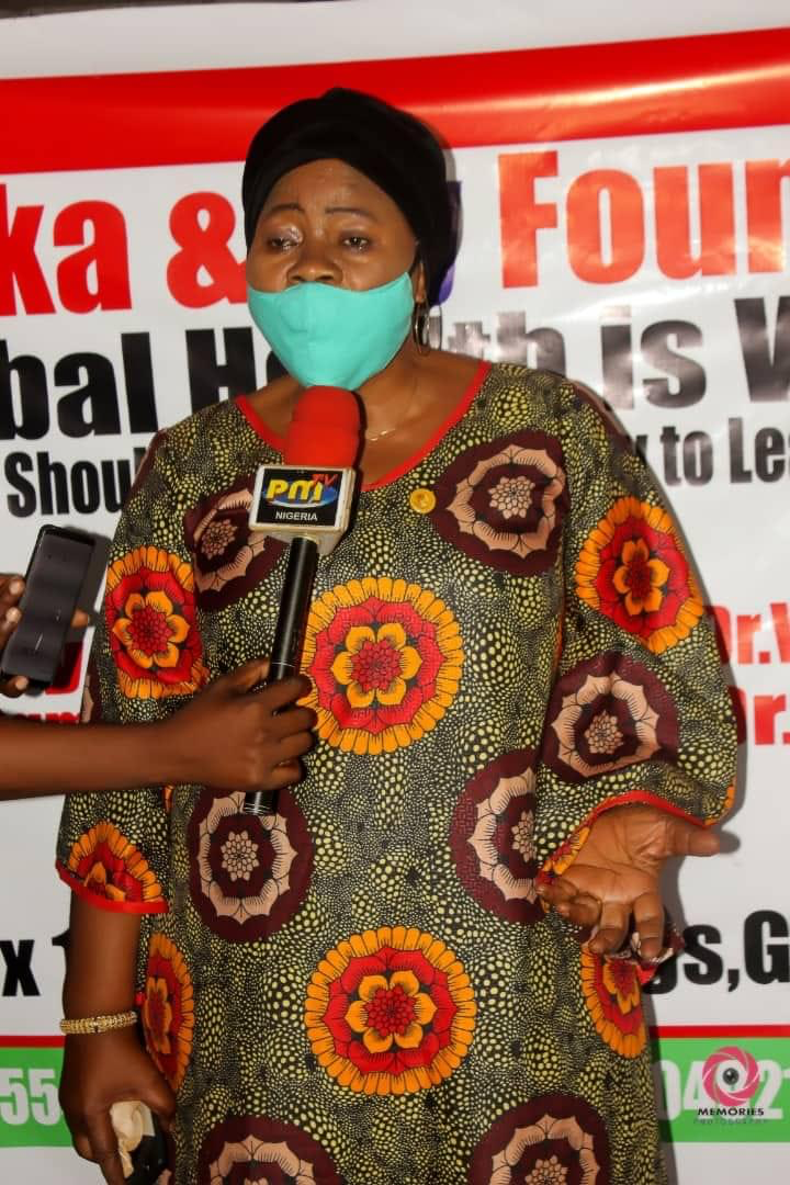 A woman wearing a mask is being interviewed by a reporter