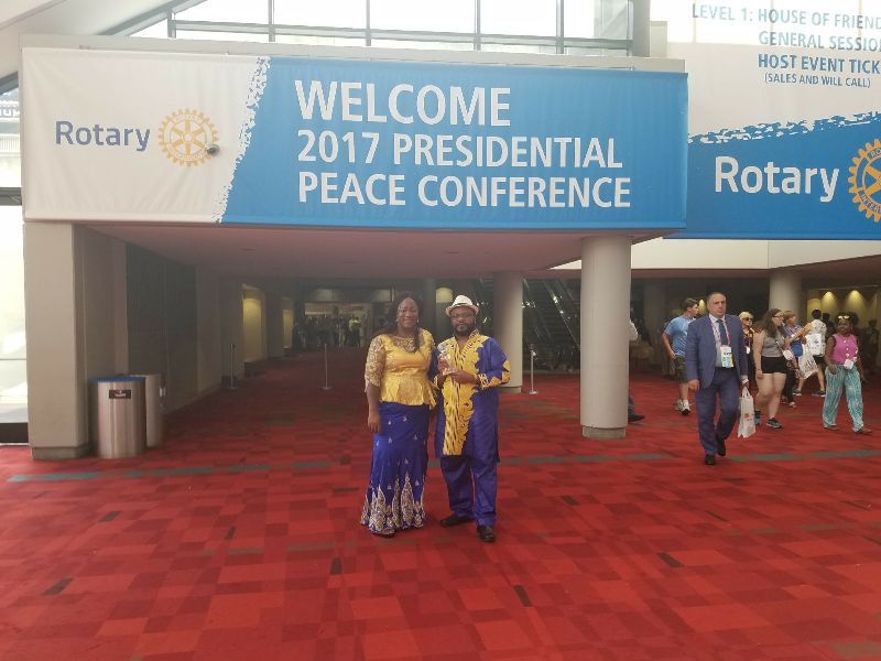 Two people standing in front of a sign that says welcome 2017 presidential peace conference