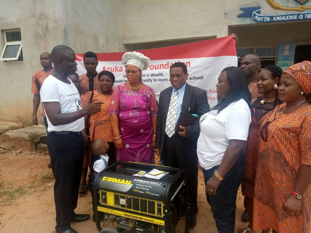A group of people are standing around a generator.