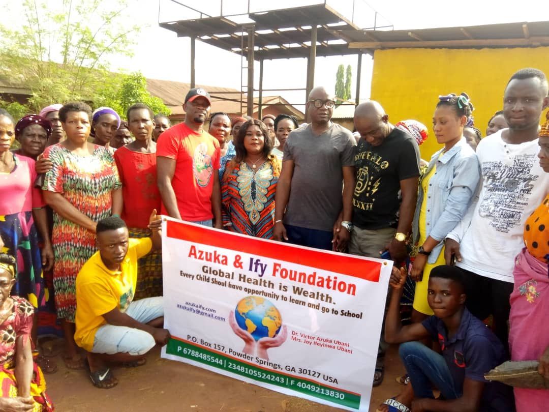 A group of people are posing for a picture while holding a sign that says aruka & ivy foundation.