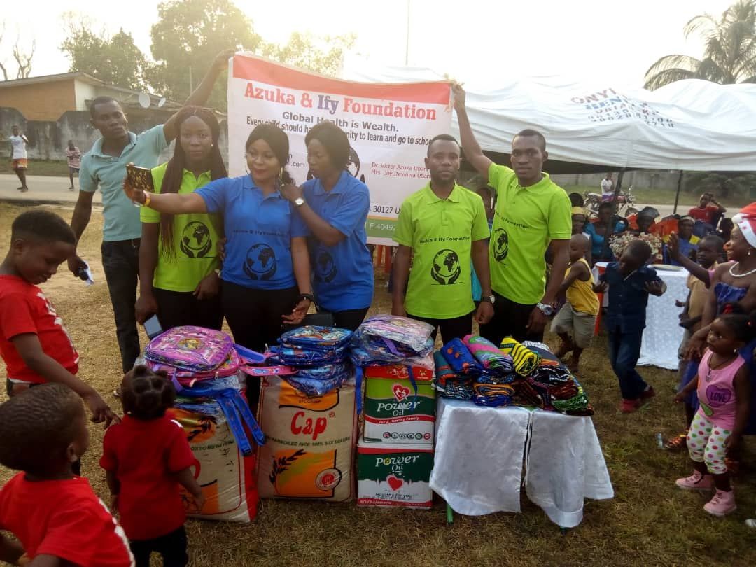 A group of people are standing in front of a table with boxes of clothes.