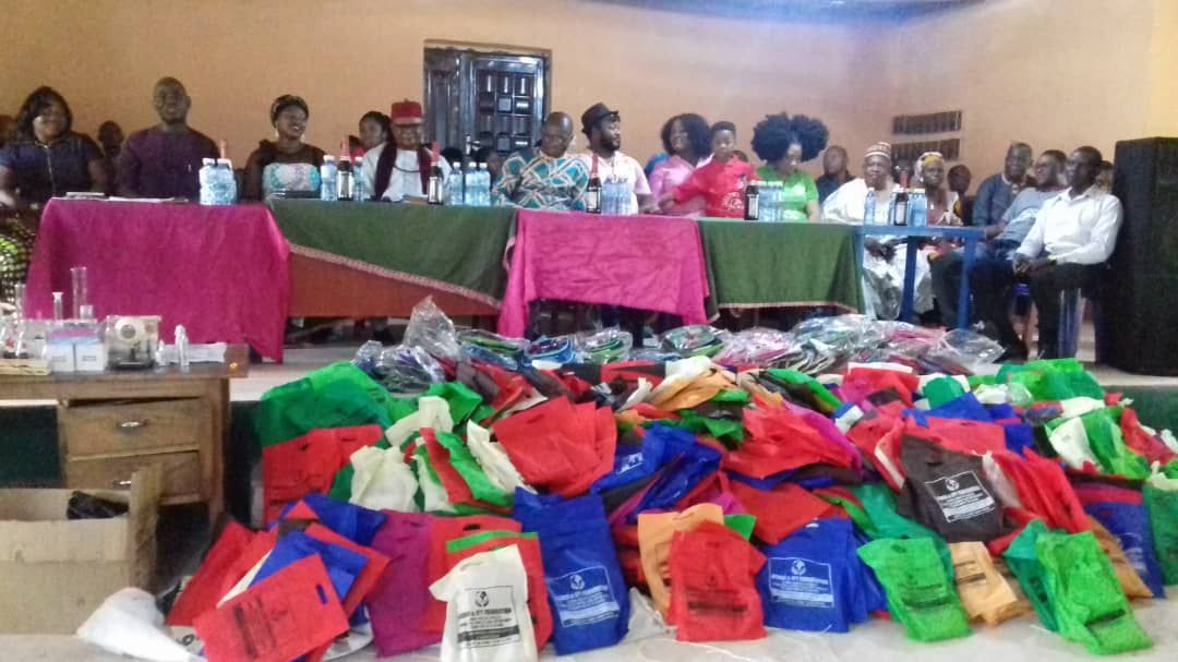 A group of people sitting around a table with a bunch of bags on the floor