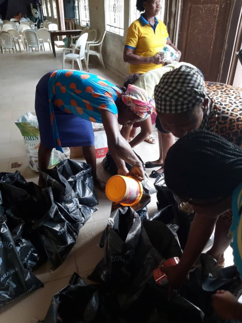 A group of people are gathered around a pile of trash bags.