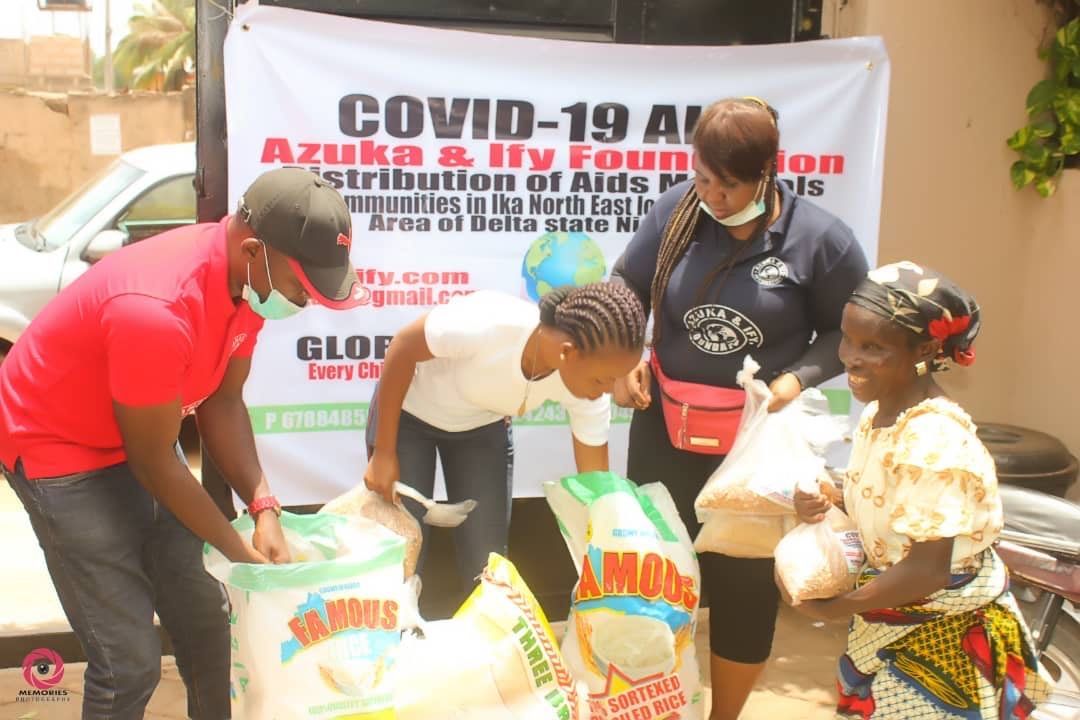 A group of people are standing around a bag of rice.