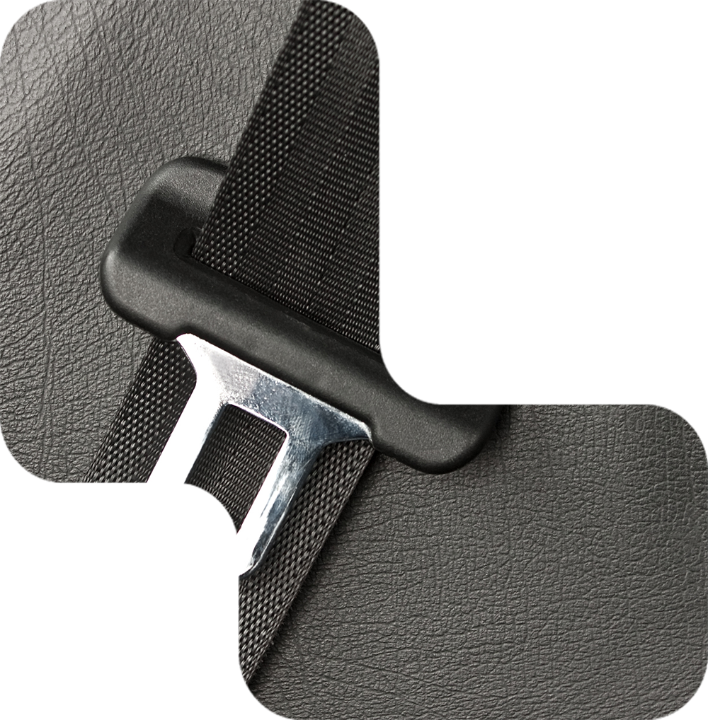 Black seatbelt buckle and strap against textured, black car interior.
