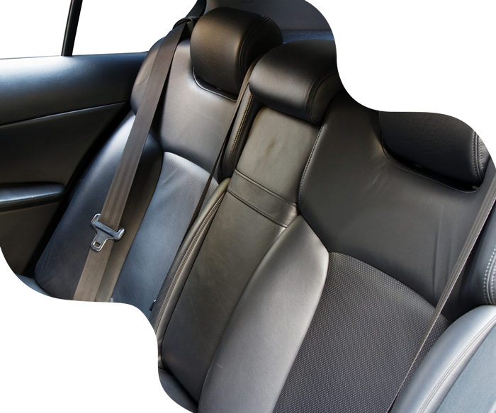 Black leather car backseats with headrests and seatbelt.