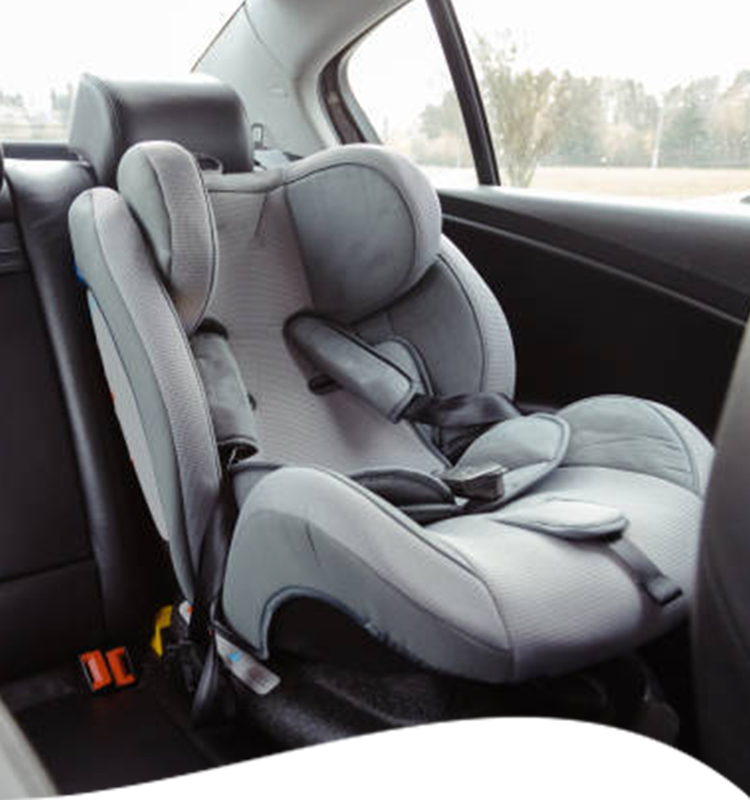 Gray car seat in the back seat of a vehicle; black interior.