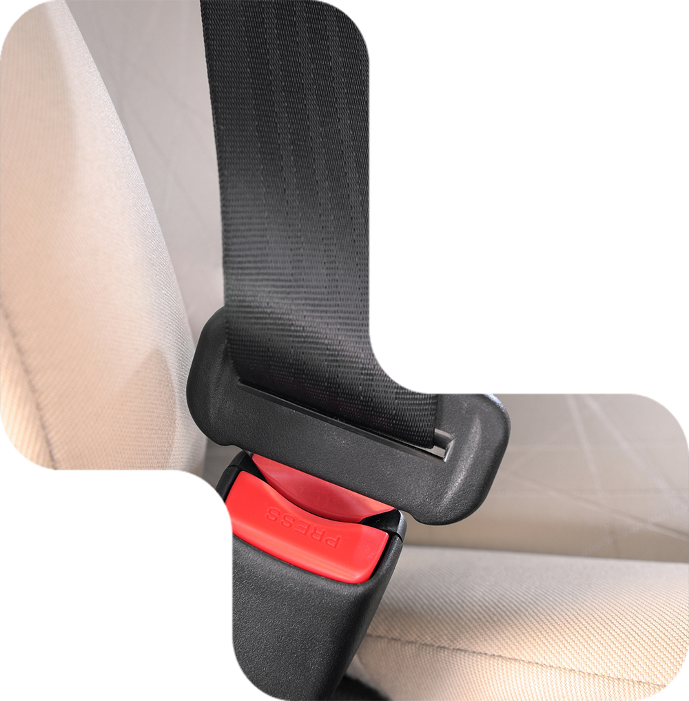 Black seatbelt buckled into the red release button on a beige car seat.