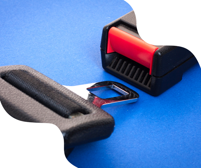 Seat belt buckle and receiver on a blue surface; red release button.