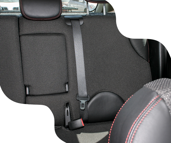 Car's black back seat with a seatbelt fastened. Red stitching accents the leather.