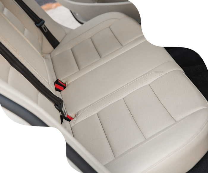 Beige car back seat with seatbelts.