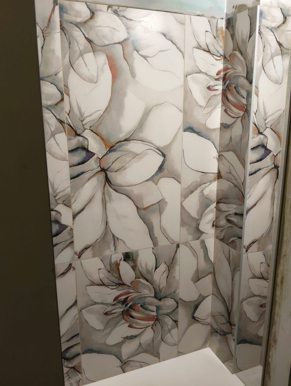 Tenda da doccia con motivo floreale in bagno, con fiori bianchi, grigi e arancioni tenui.