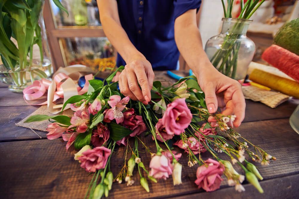 Female Florist Working With Flowers in Workshop — Castletown Flower Hut in Pimlico, QLD