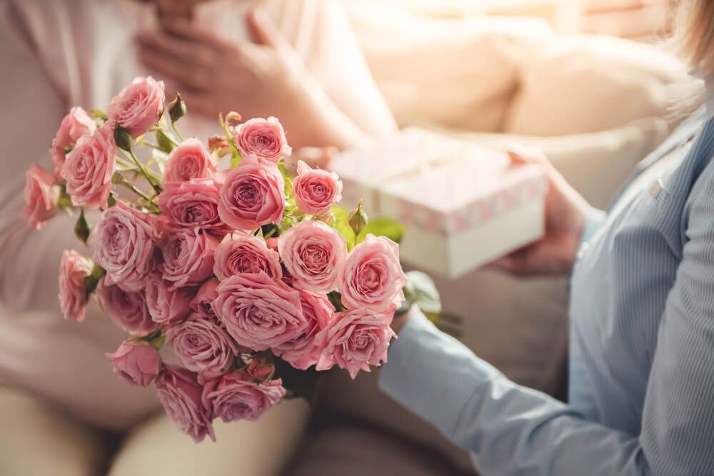 Woman giving flowers and a gift box to her mother — Castletown Flower Hut in Pimlico, QLD