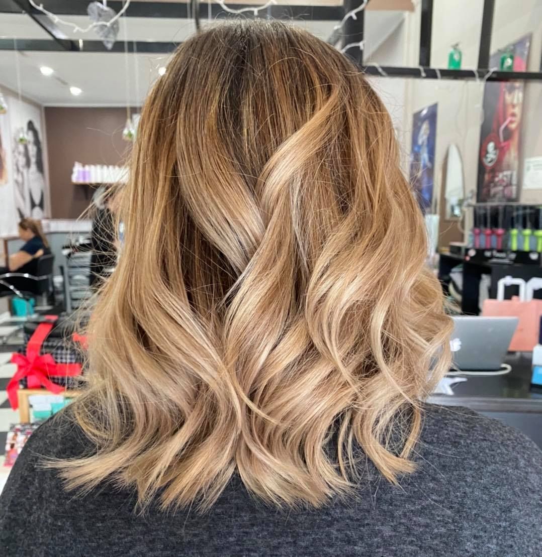 A Woman with Long Blonde Hair Is Standing in A Salon — Ammo Hair and Beauty In Maclean, NSW