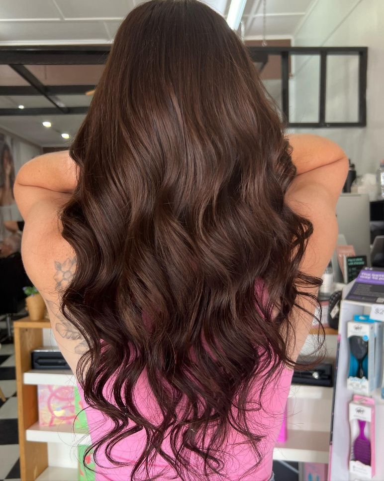 A Woman with Long Brown Hair Is Wearing a Pink Tank Top — Ammo Hair and Beauty In Maclean, NSW