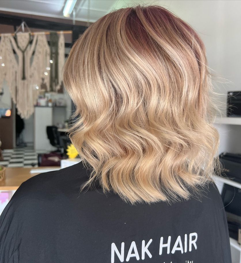 A Woman with Blonde Hair Is Wearing a Black Shirt — Ammo Hair and Beauty In Maclean, NSW