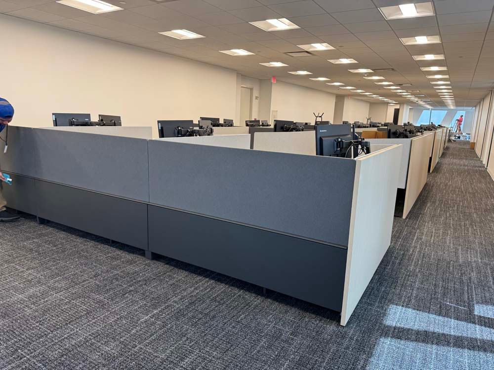 A man is cleaning cubicles in an office building.