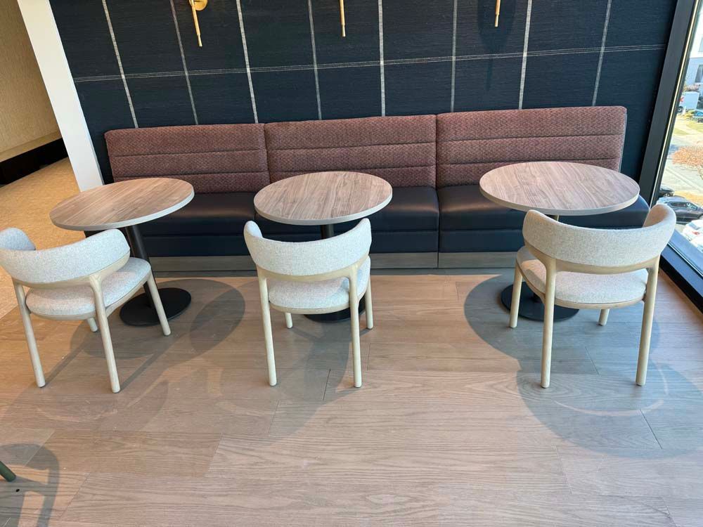 A row of tables and chairs in a room with a couch.
