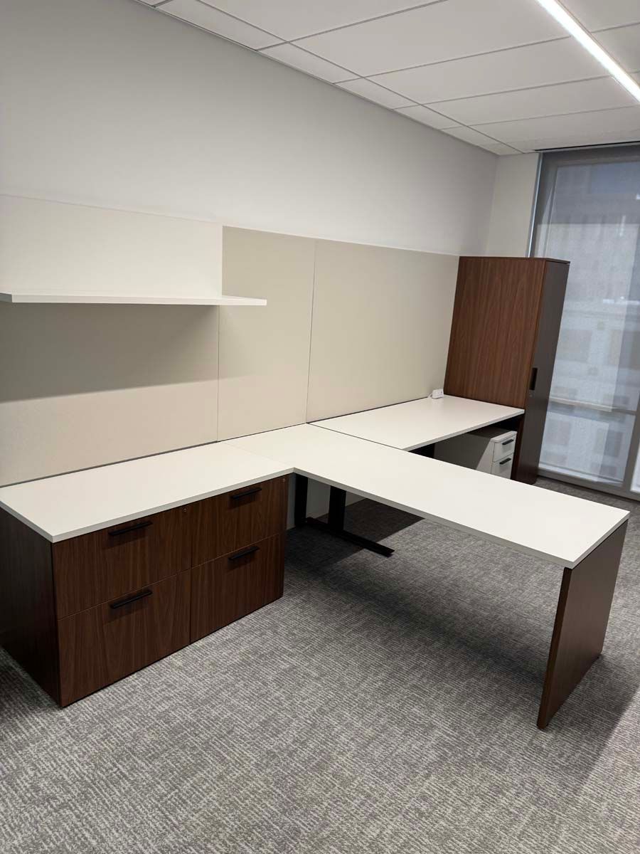 A large l shaped desk with drawers underneath it in an office.
