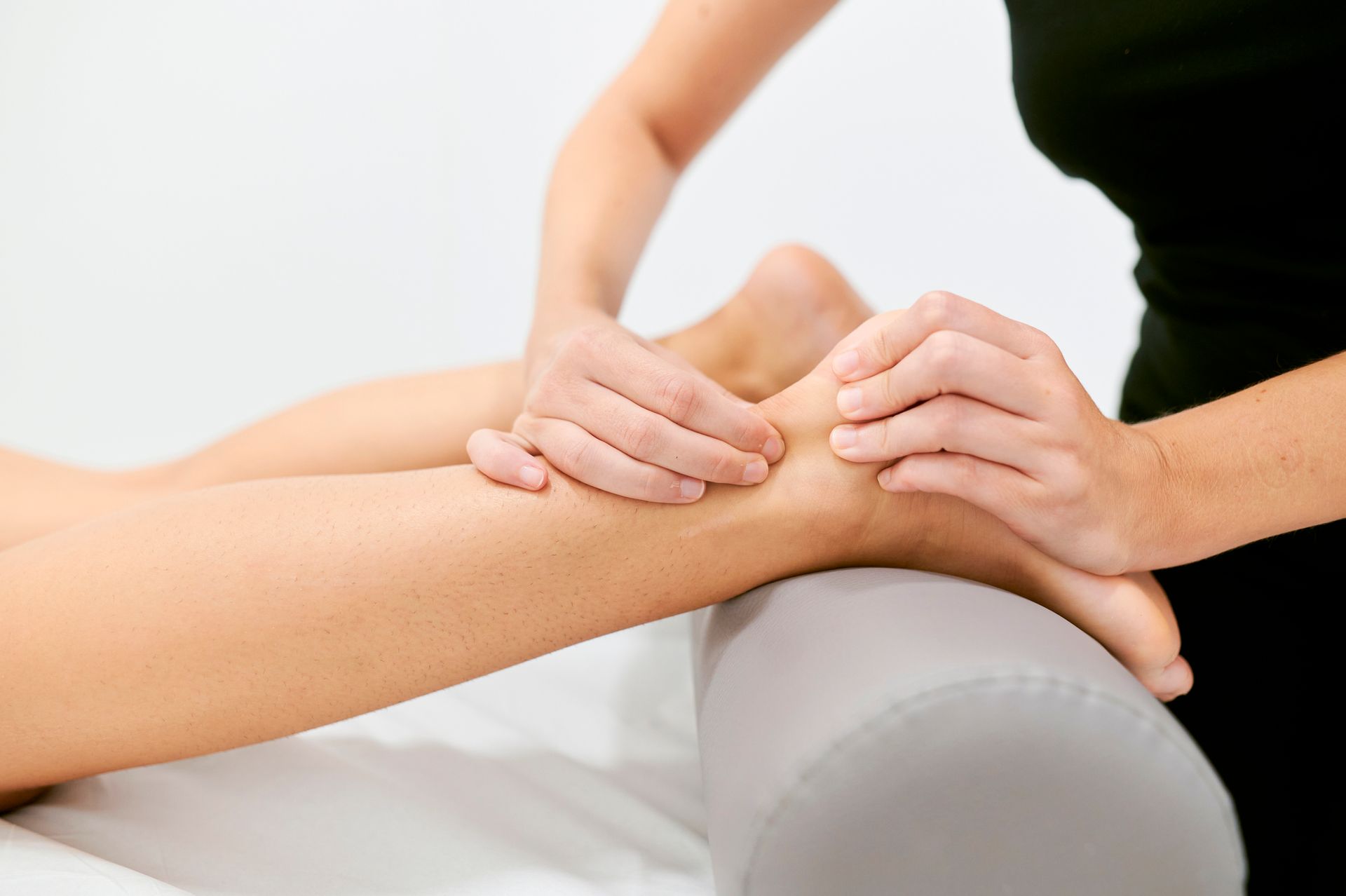 A woman is giving a foot massage to another woman