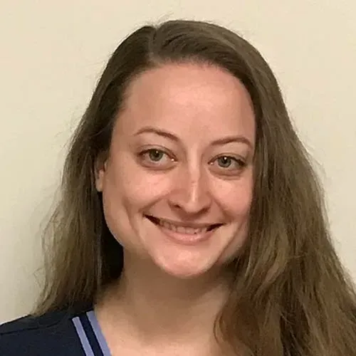 A woman with long hair is smiling for the camera.