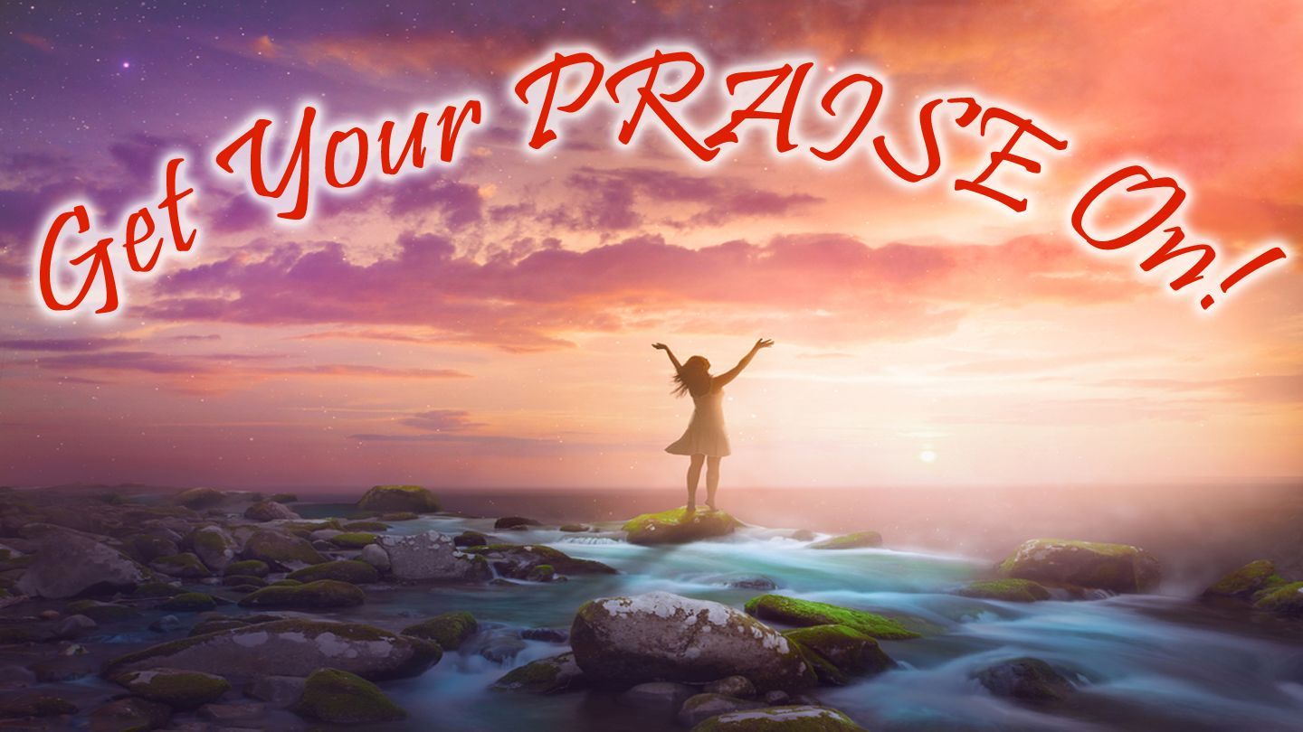 Woman with arms raised, on rocks by water, 