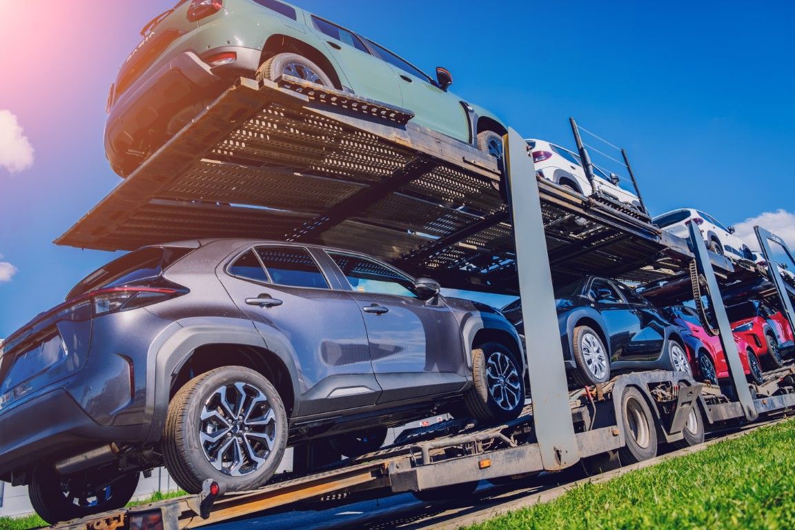 Open carrier car shipping semi truck driving on highway