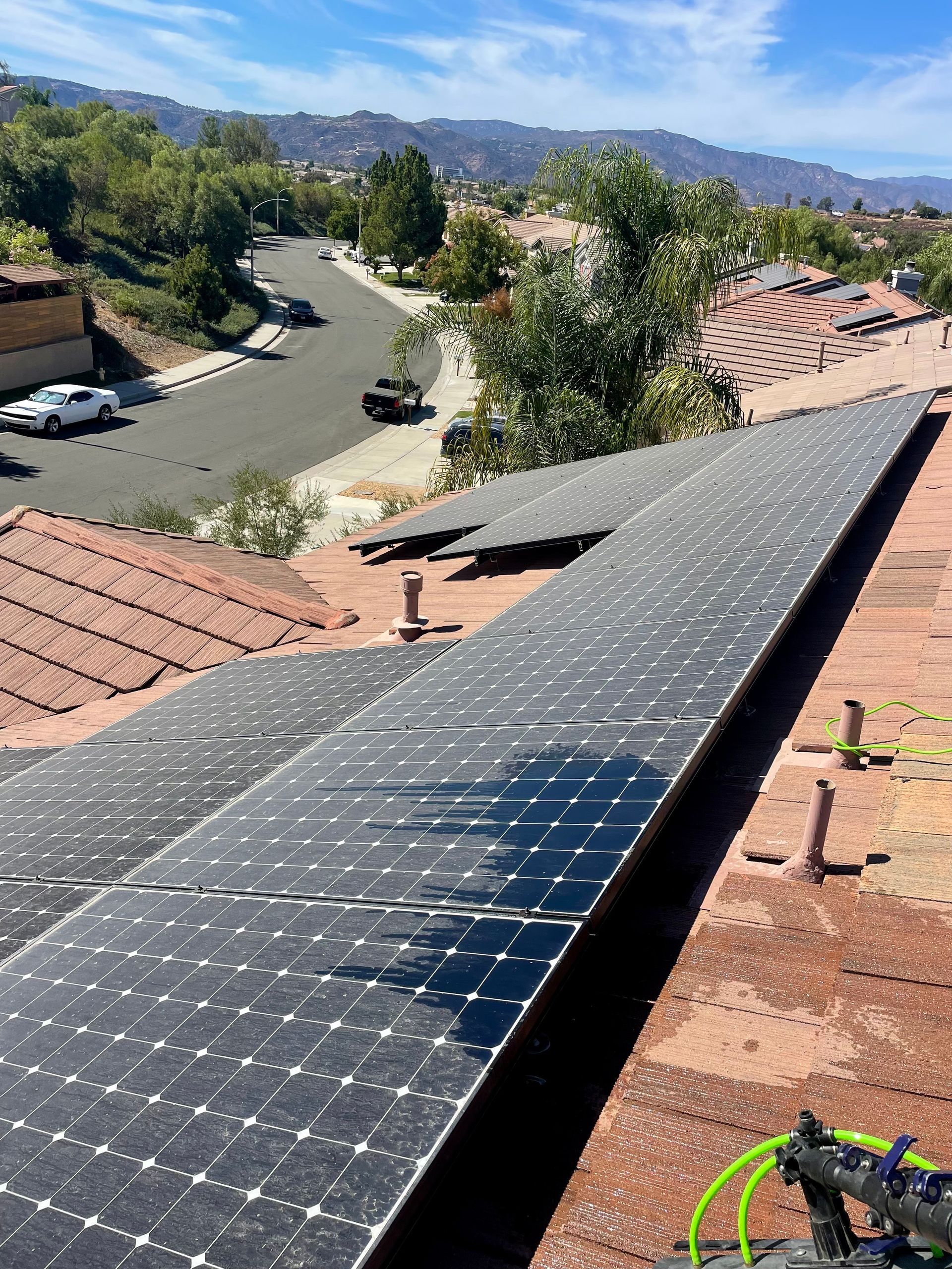 A row of solar panels are sitting on top of a roof.