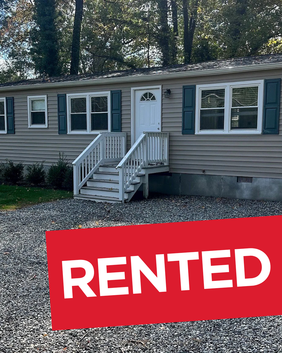Single-story gray house with white trim and a red “RENTED” sign in front