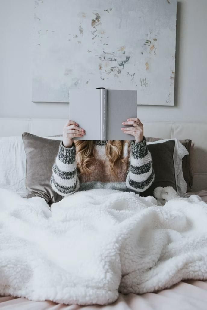 A person cozy in their bed