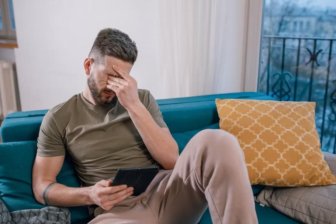 A man looks uncomfortable at home.